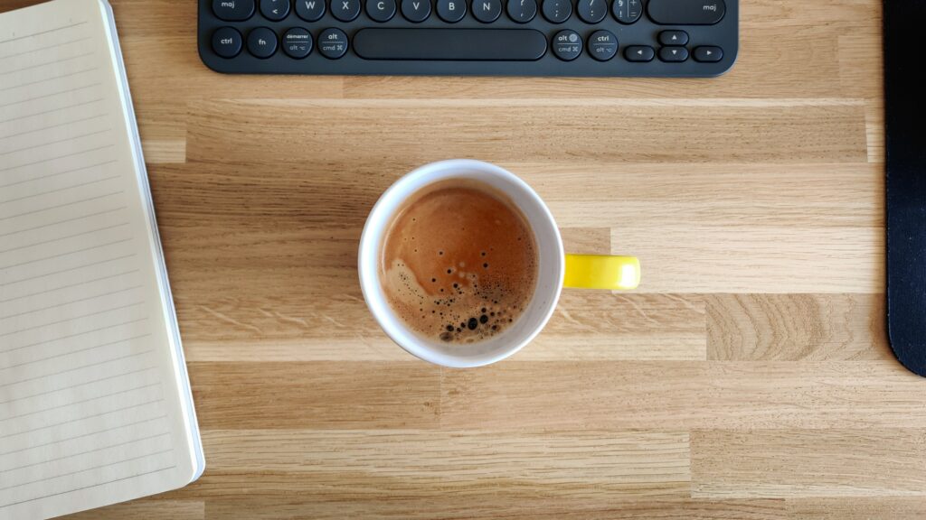 Eine Tasse Kaffee auf einem Tisch mit einem Laptop